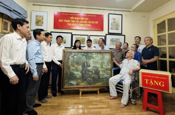 Nghi thức trao tặng bức tranh “Bác Hồ làm việc tại Pác Bó” giữa họa sĩ Trịnh Phòng và gia đình với Đoàn công tác tỉnh Cao Bằng
